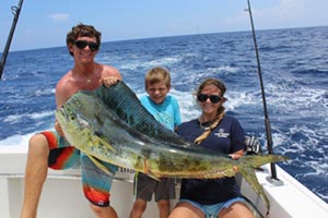 three family members holding one big fish recently caught
