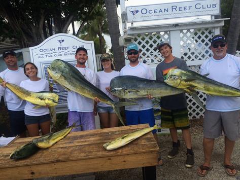 group of people each holding massive fish